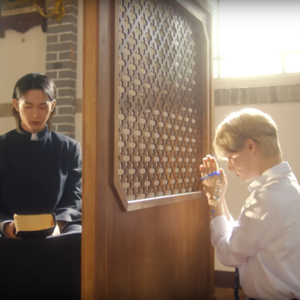 leedo dressed as a priest and hwanwoong praying with a rosary